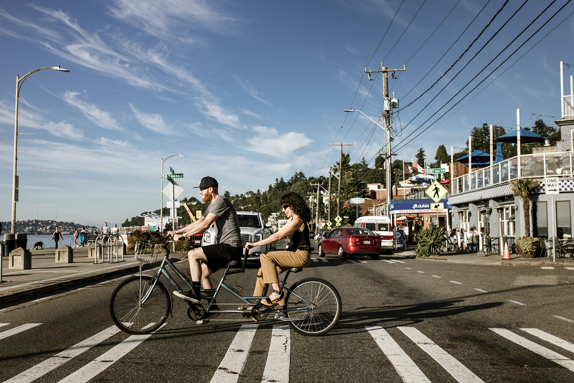 A couple is tandem biking on a beach in West Seattle