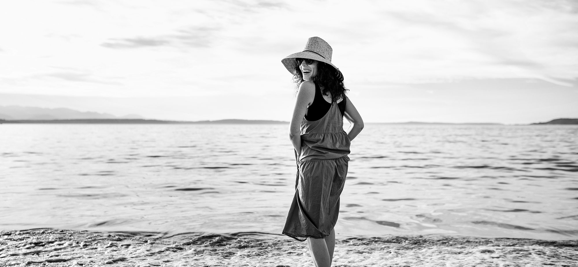 Person smiling on a beach in West Seattle in Black and White