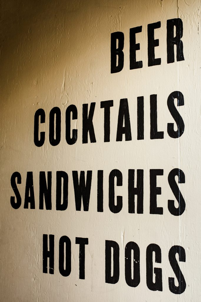 stencil sign that says Beer Cocktails Sandwiches Hot Dogs